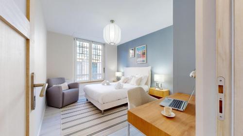 a bedroom with a bed and a desk with a laptop at expat renting - Le Volta - Terrasse - Netflix in Toulouse