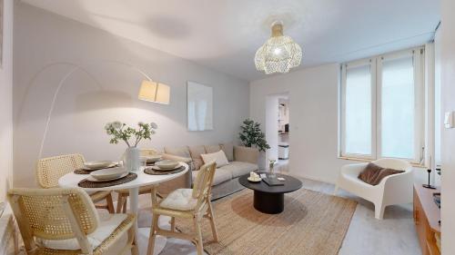 un salon avec une table et un canapé dans l'établissement expat renting - Le Volta - Terrasse - Netflix, à Toulouse