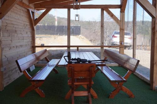 a picnic table and two benches in a cabin at Cabana Brad Apuseni in Rîmeţi