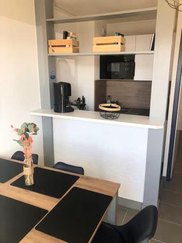 une cuisine avec une table, des chaises et un comptoir dans l'établissement Charmant duplex avec belle vue mer la plage à 100 m, à Saint-Nic