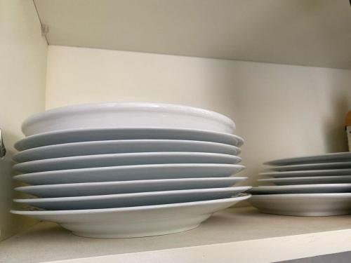 a stack of plates sitting on top of a shelf at Lovely 4Bedroom Home in Akright - Tara Residence Akright in Buzzi