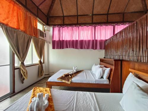 a bedroom with two beds and a window at Casa de Arte in Boracay