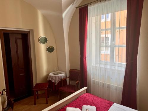 a bedroom with a bed and a window and a table at (Ne)vinná kavárna in Mikulov