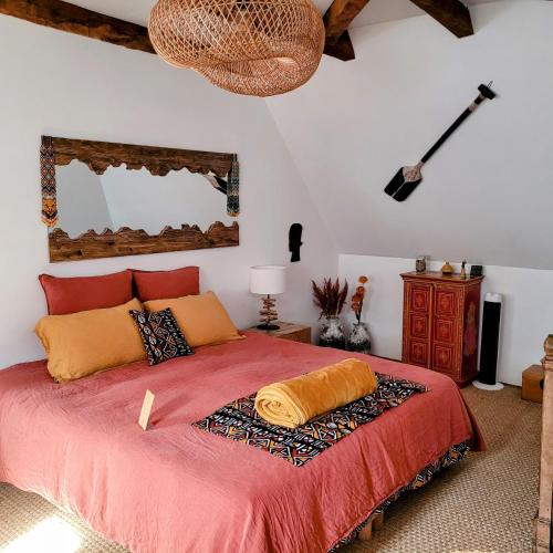 - une chambre avec un lit doté d'un couvre-lit rouge dans l'établissement Manoir des Pélies SPA, à Conques