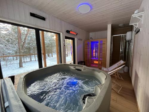 a jacuzzi tub in a room with snow outside at 3pokoje - Domek lub Pokój pod lasem na odludziu, jacuzzi, sauna, kominek, Roztocze in Susiec