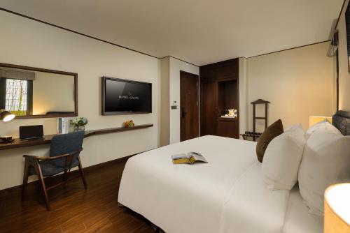 a hotel room with a white bed and a tv at HOTEL de LAGOM in Hanoi