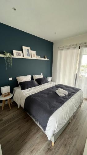 - un grand lit dans une chambre dotée d'un mur bleu dans l'établissement Villa CARPE DIEM - Bretignolles sur Mer, à Bretignolles-sur-Mer