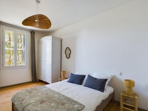 une chambre avec un lit blanc avec des oreillers bleus dans l'établissement Mas Sainte Croix - Renovated old Provencal Mas, à Fontvieille