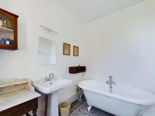 une salle de bain blanche avec une baignoire et un lavabo dans l'établissement Mas Sainte Croix - Renovated old Provencal Mas, à Fontvieille