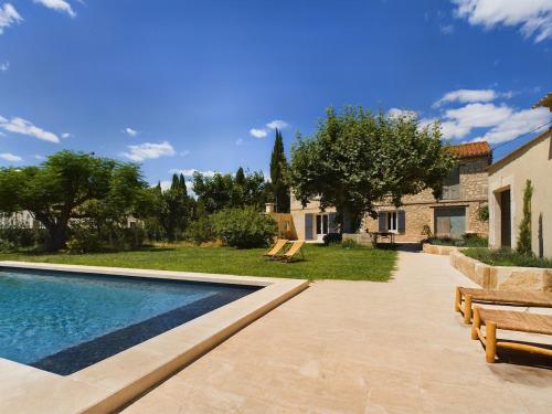 une cour arrière avec une piscine et une maison dans l'établissement Mas Sainte Croix - Renovated old Provencal Mas, à Fontvieille