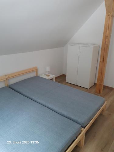 a bedroom with a bed with a blue mattress at Chata AmBach in Liberk