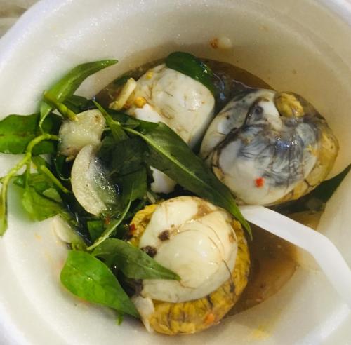 a white bowl of food with oysters and greens at Bloom Garden Bed & Breakfast in Siem Reap