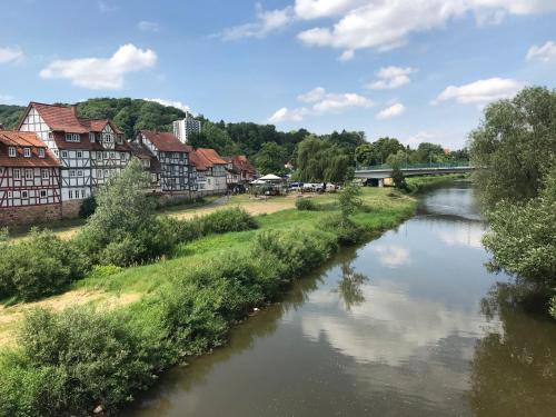 a river in a town with houses and a bridge at Ferienhaus Am Fulda Ufer in Rotenburg an der Fulda