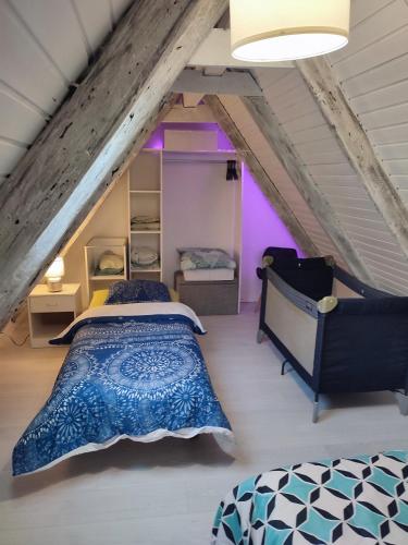 une chambre mansardée avec un lit et une chaise dans l'établissement duplex aux portes de Strasbourg tram 100m, à Schiltigheim