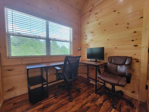 a desk with a computer and a chair in a cabin at Skyline Chalet in Rogers