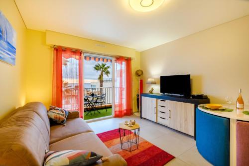 un salon avec un canapé et une télévision dans l'établissement Studio Etoile De Mer - Vue mer, à Villeneuve-Loubet