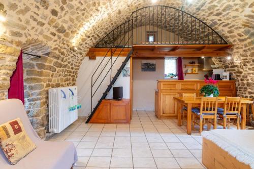 a kitchen and dining room with an archway and a table at Gîte La Voûte Céleste 2/3 pers aux Bondons in Les Bondons
