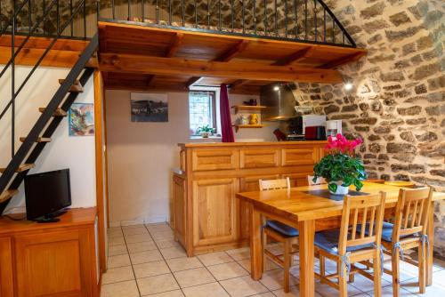 a kitchen and dining room with a wooden table and chairs at Gîte La Voûte Céleste 2/3 pers aux Bondons in Les Bondons