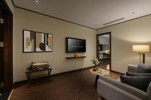 a living room with a couch and a tv on the wall at HOTEL de LAGOM in Hanoi