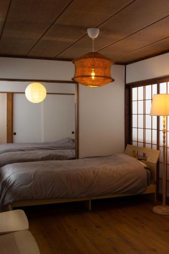a bedroom with two beds and two lamps at TEIEN stay sauna in Ōtani