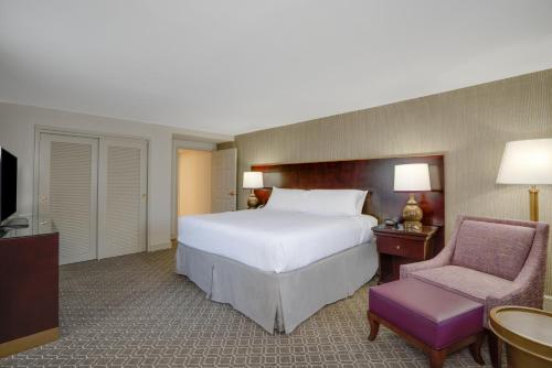 a bedroom with a large bed and a chair at Crowne Plaza New Orleans French Qtr - Astor by IHG in New Orleans
