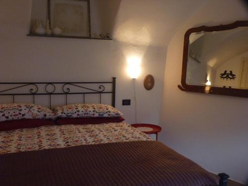 a bedroom with a bed and a large mirror at Archi del '400 Appartamento in Barolo