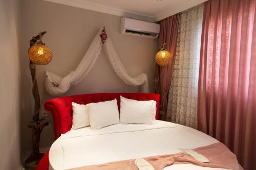 a bed with a red headboard in a bedroom at Şirinyer Elit Residance Apart Hotel in Izmir