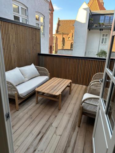 a patio with a couch and a coffee table on a balcony at STAYplaza in Kolding