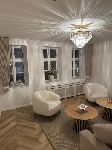 a living room with two white chairs and a chandelier at STAYplaza in Kolding