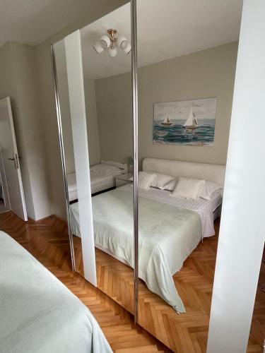 a bedroom with two beds and a mirror at Villa Norah in Podgora