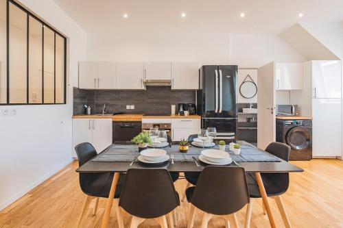 une salle à manger avec une table et des chaises dans une cuisine dans l'établissement Stuart élégance vue Cathédrale, à Reims