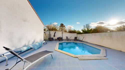 une piscine sur une terrasse à côté d'un mur dans l'établissement expat renting - Le Corail - Villa - Piscine - Wifi, à Saint-Orens-de-Gameville
