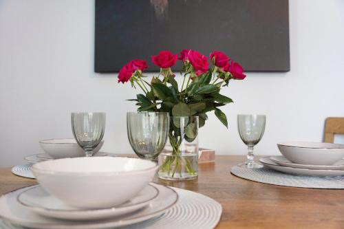 a table with red roses in a vase with glasses at Spreequartier in Malschwitz