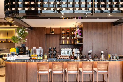 a bar with six chairs in a restaurant at Chengdu Junting Hotel Southwestern University of Finance and Economics Metro Branch in Chengdu