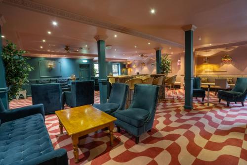 a lobby with chairs and tables in a hotel at Waterton Park Hotel in Wakefield