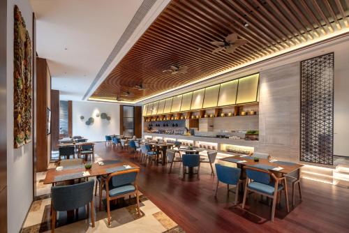 a restaurant with wooden tables and chairs and a bar at Chengdu Junting Hotel Southwestern University of Finance and Economics Metro Branch in Chengdu
