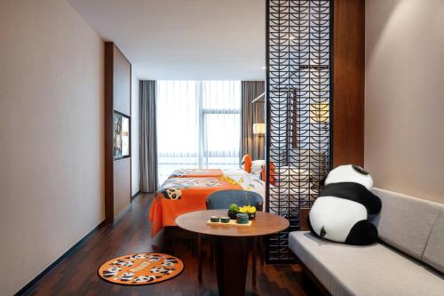 a bedroom with a bed and a table and a couch at Chengdu Junting Hotel Southwestern University of Finance and Economics Metro Branch in Chengdu