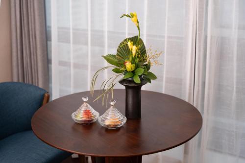 a table with a vase with flowers in it at Chengdu Junting Hotel Southwestern University of Finance and Economics Metro Branch in Chengdu