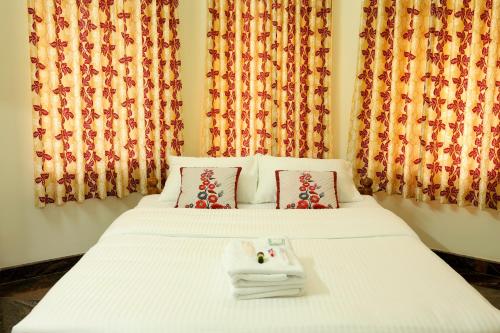 a white bed with a tray of towels on it at Kunnumpurathu Holidays & Homestay in Kottayam