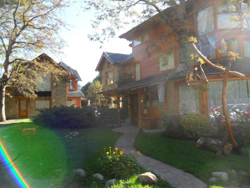 a house with a rainbow in front of it at Apart Hotel del Pellin in San Martín de los Andes