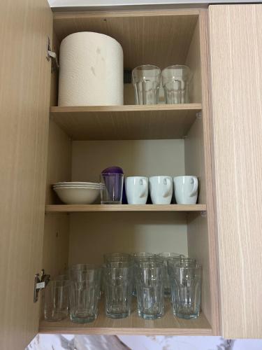 a cabinet filled with lots of glass bowls and plates at Maren apartment in Orikum