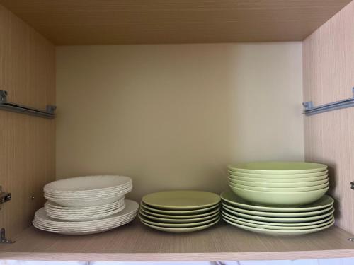 a group of plates sitting on a shelf in a cabinet at Maren apartment in Orikum
