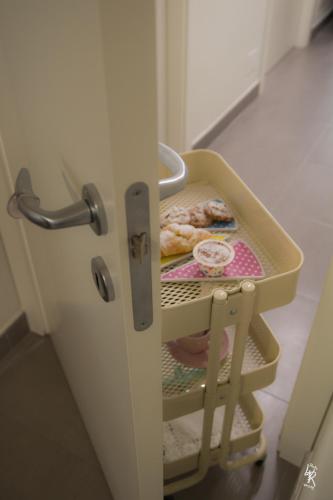 an open refrigerator door with a cart of donuts at B&B Mar del Plata in Porto Recanati