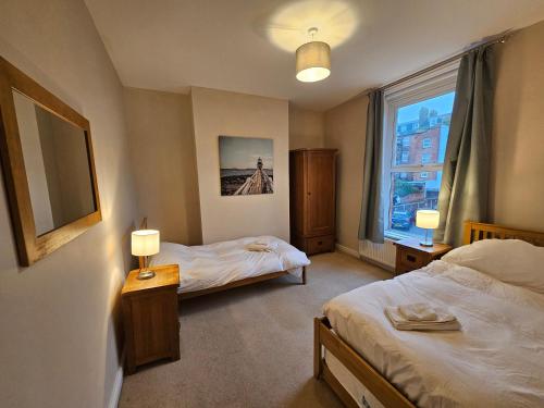 une chambre d'hôtel avec deux lits et une fenêtre dans l'établissement Freshford House, à Weymouth