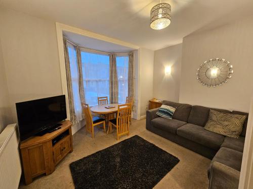 a living room with a couch and a tv and a table at Freshford House in Weymouth
