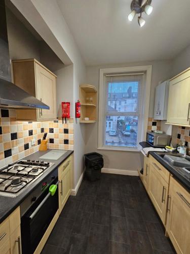 a kitchen with a stove and a sink and a window at Freshford House in Weymouth