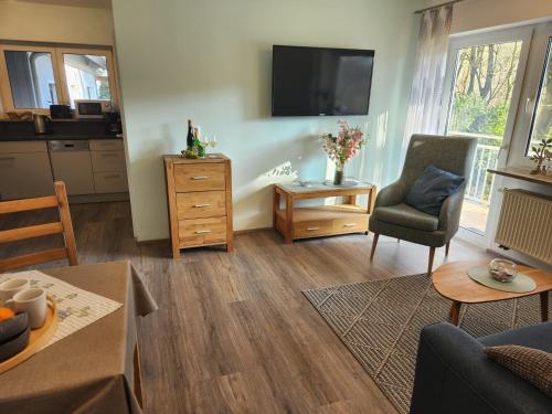 a living room with a tv and a couch and a table at Winzerhof Düring in Iphofen