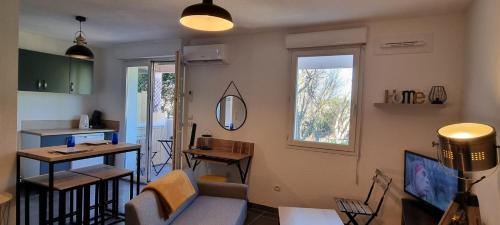 un salon avec un canapé et une table dans l'établissement Jardin des oiseaux, à Narbonne