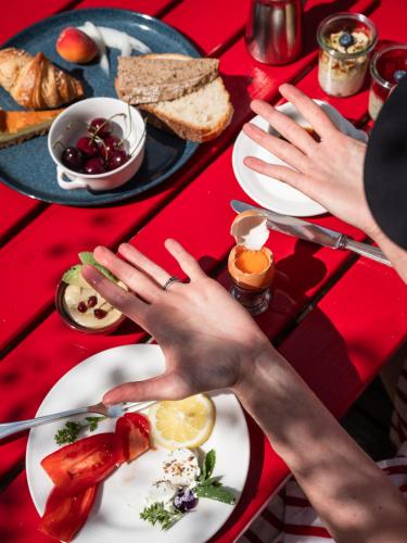 a person reaching for a plate of food on a table at Frida am Wald in Rasùn di Sotto