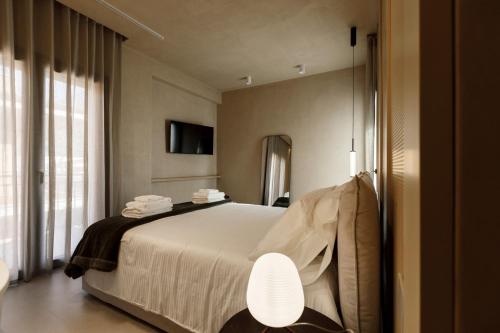 a bedroom with a large bed and a mirror at La Rotta Rooms in Agrigento